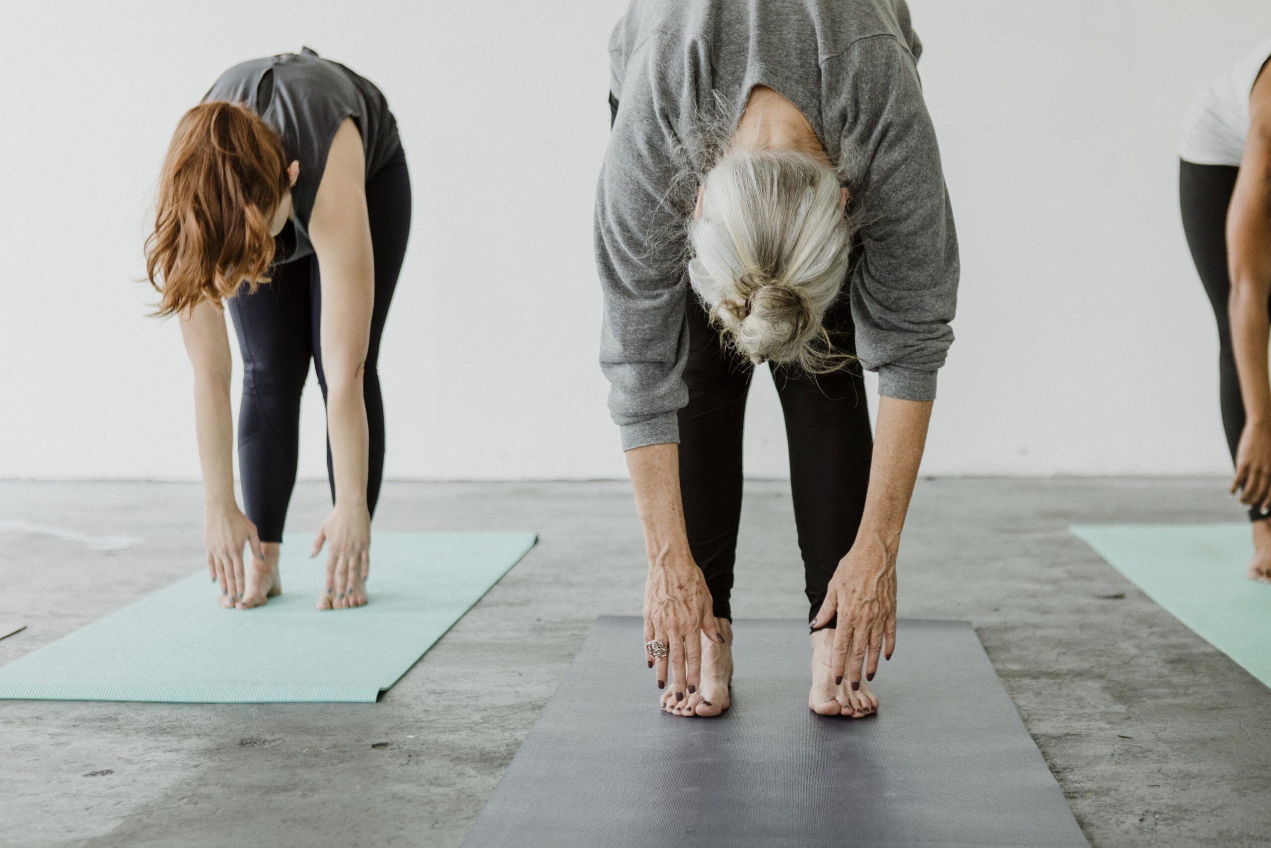 Sporty people practicing Uttanasana pose